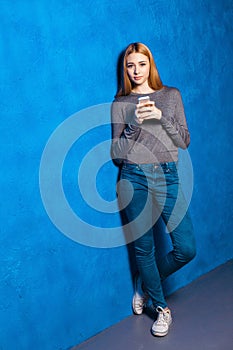 Cute girl against blue wall