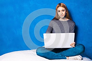 Cute girl against blue wall