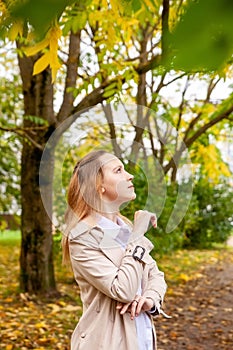 Cute girl on  autumn day against  background of yellow leaves