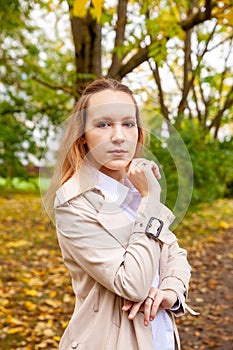 Cute girl on  autumn day against  background of yellow leaves