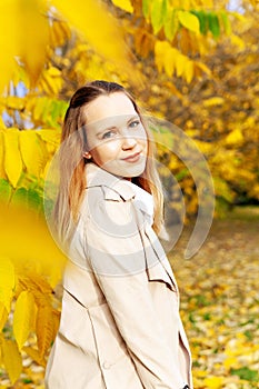 Cute girl on  autumn day against  background of yellow leaves