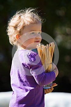 Cute girl baby with blond hairs holds glass