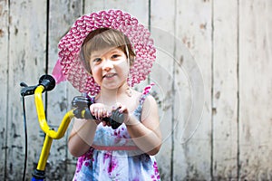 Cute girl with bicycle against wooden backdrop