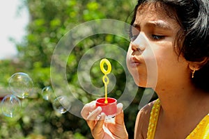 Cute girl blowing bubbles