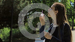 Cute girl blowing soap bubbles