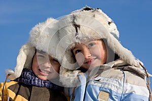 Cute girl and boy in the fur-cap