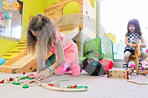 Cute girl building a structure in balance during playtime at the kindergarten