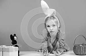 Cute girl in bunny ears on Easter day. Girl holding painted eggs.
