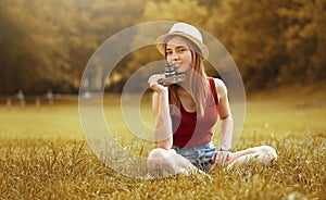 Cute girl with camera on grass autumn