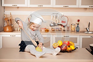 Cute girl with chef hat holding big wooden spoon