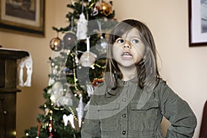 Cute girl child of five or six year old reciting the Christmas poem in the living room in front of the christmas tree - Childhood