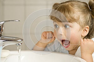 Cute girl cleaning teeth by floss