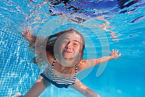 Cute girl diving under water of swimming pool