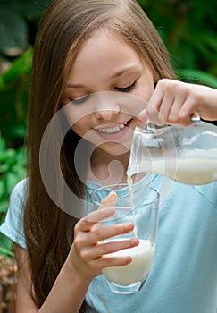 Cute girl drinking milk. Little young lady holds glass of milk. Organic farm products