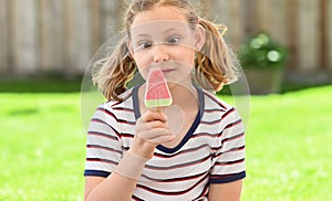 Cute girl eating ice-cream in park