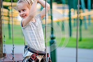 Teenage girl goes on hinged trail in rope park.