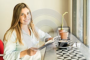 Cute girl enjoying coffee and reading