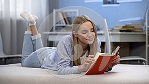 Cute girl enjoying romantic poems, reading book, dreaming of perfect relations