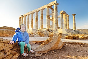 Cute girl exploring the Ancient Greek temple of Poseidon at Cape Sounion, one of the major monuments of the Golden Age of Athens