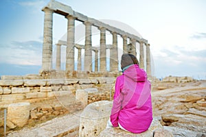 Cute girl exploring the Ancient Greek temple of Poseidon at Cape Sounion, one of the major monuments of the Golden Age of Athens