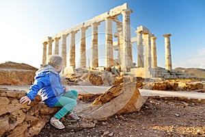 Cute girl exploring the Ancient Greek temple of Poseidon at Cape Sounion, one of the major monuments of the Golden Age of Athens