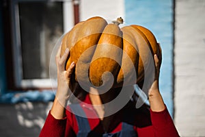 Cute girl famer at the autumn pumpkin patch background. Having fun and posing.