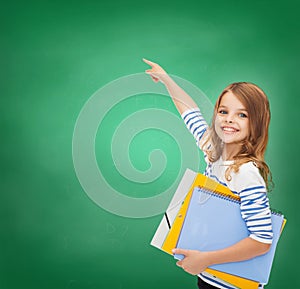 Cute girl with folders pointing at virtual screen