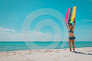 cute girl go surfing on tropical beach