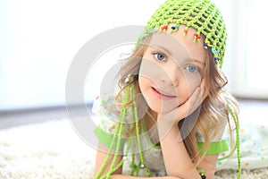 Cute girl green hat white carpet