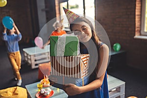 Cute girl in a hat holding presents and smiling