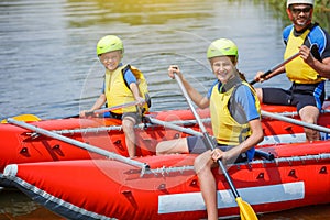 Cute girl in helmet and live vest with paddle ready for rafting on the catamaran