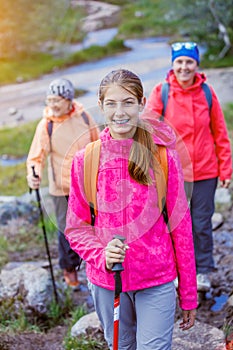 Cute girl with hiking equipment in the mountains
