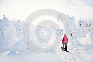 Cute girl hiking in snowshoes