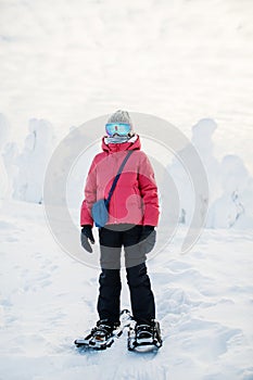Cute girl hiking in snowshoes