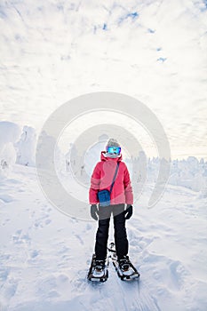 Cute girl hiking in snowshoes