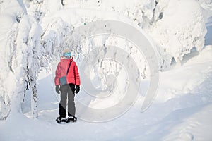 Cute girl hiking in snowshoes