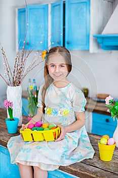Cute girl holding basket with painted eggs