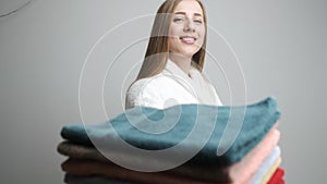 Cute girl holding colored towels and posing in front of the camera