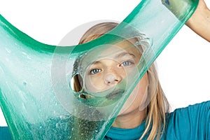 Cute girl holding a green slime with a hole in front of her face