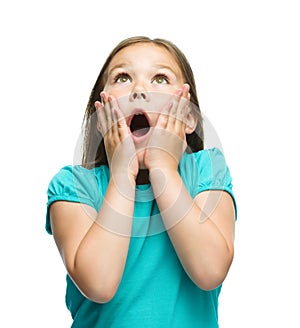 Cute girl is holding her face in astonishment