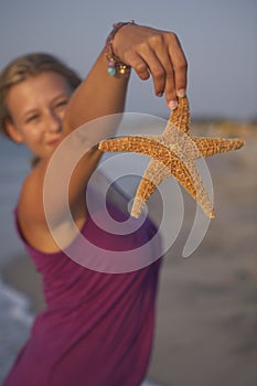 Cute girl is holding seastar photo