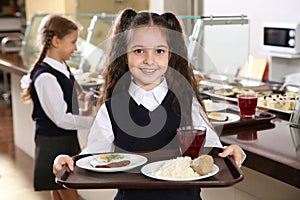 Cute girl holding tray with healthy food