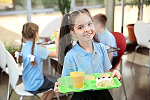 Cute girl holding tray with healthy food