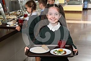 Cute girl holding tray with healthy food