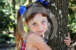 Cute girl hugging tree