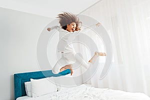 Cute girl jumping on the bed, happiness