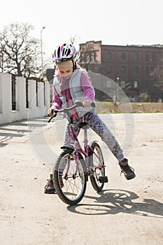 Cute girl learns to ride a bike