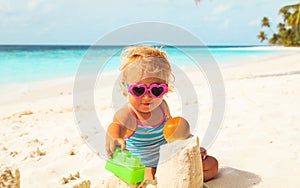 Cute girl little play with sand on beach