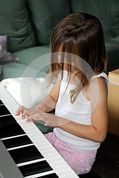 Malý hudobník ponorený na klávesnica 