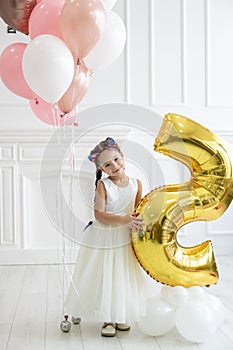 Vertical portrait of a cute five year old girl in a white studio